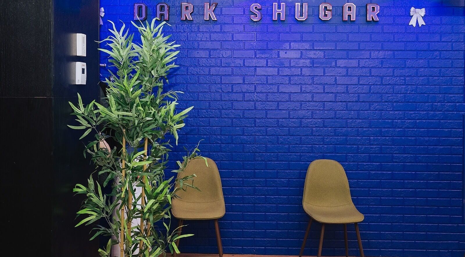 Relaxing lounge area at Dark Shugar Hair & Beauty Studios, St Vital in Winnipeg, Manitoba, CA with blue walls.