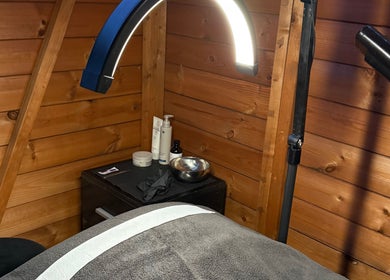 Warm wooden treatment room at The Beauty Lounge, Wigston, England, GB, with spa table and ambient lighting.