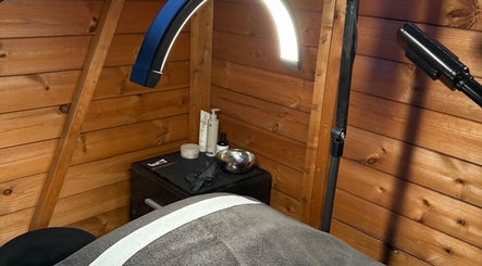 Warm wooden treatment room at The Beauty Lounge, Wigston, England, GB, with spa table and ambient lighting.