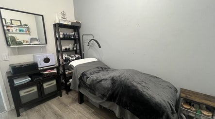 Treatment room at Sugar and Stone Aesthetics in Kingston, Ontario, CA featuring a plush bed and organized shelves.