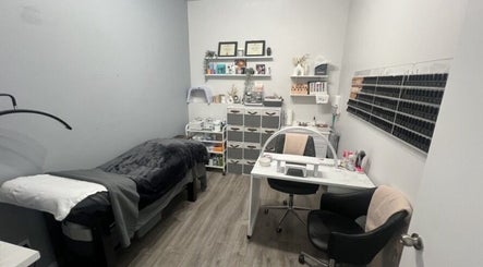 Cozy treatment room at Sugar and Stone Aesthetics, Kingston, Ontario, CA. Features massage bed and nail polish wall.