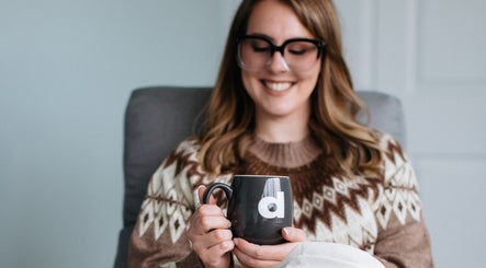 Relaxed woman enjoying a warm drink at Sugar and Stone Aesthetics in Kingston, Ontario, CA.