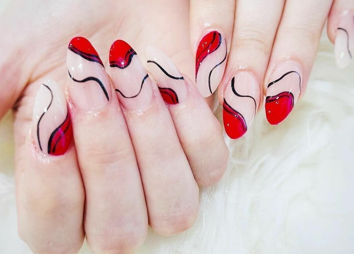 Intricate red and black nail art at Creative Nail Spa, West Des Moines, Iowa, US.