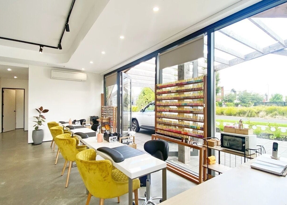 Interior of Bella Signature Nails in Auckland, NZ showcasing sleek nail stations and vibrant polish display.