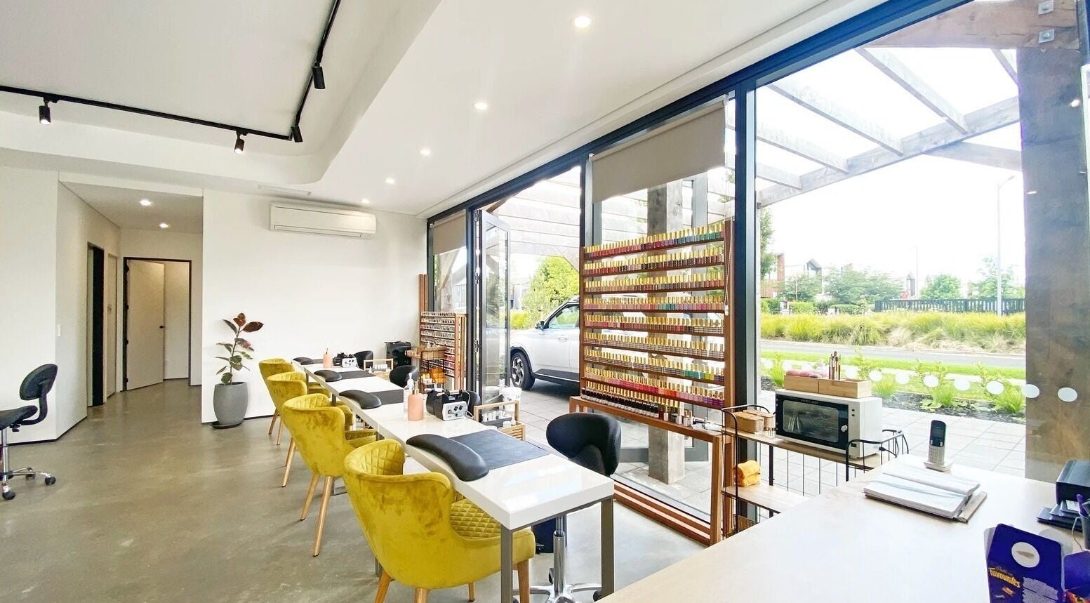 Interior of Bella Signature Nails in Auckland, NZ showcasing sleek nail stations and vibrant polish display.