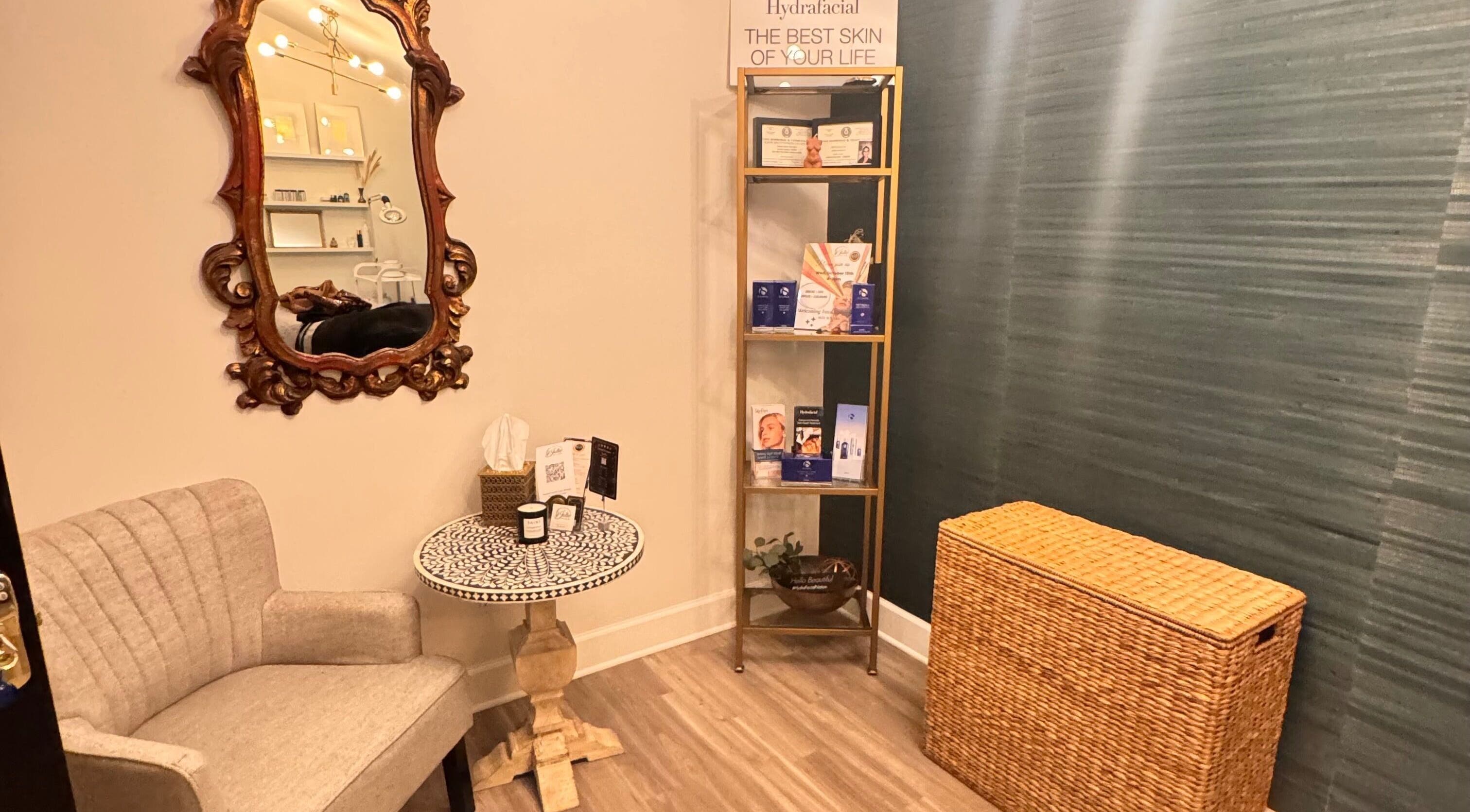 Cozy corner at Jolie Skin Studio, Austin, Texas, US, with ornate mirror and chic seating.