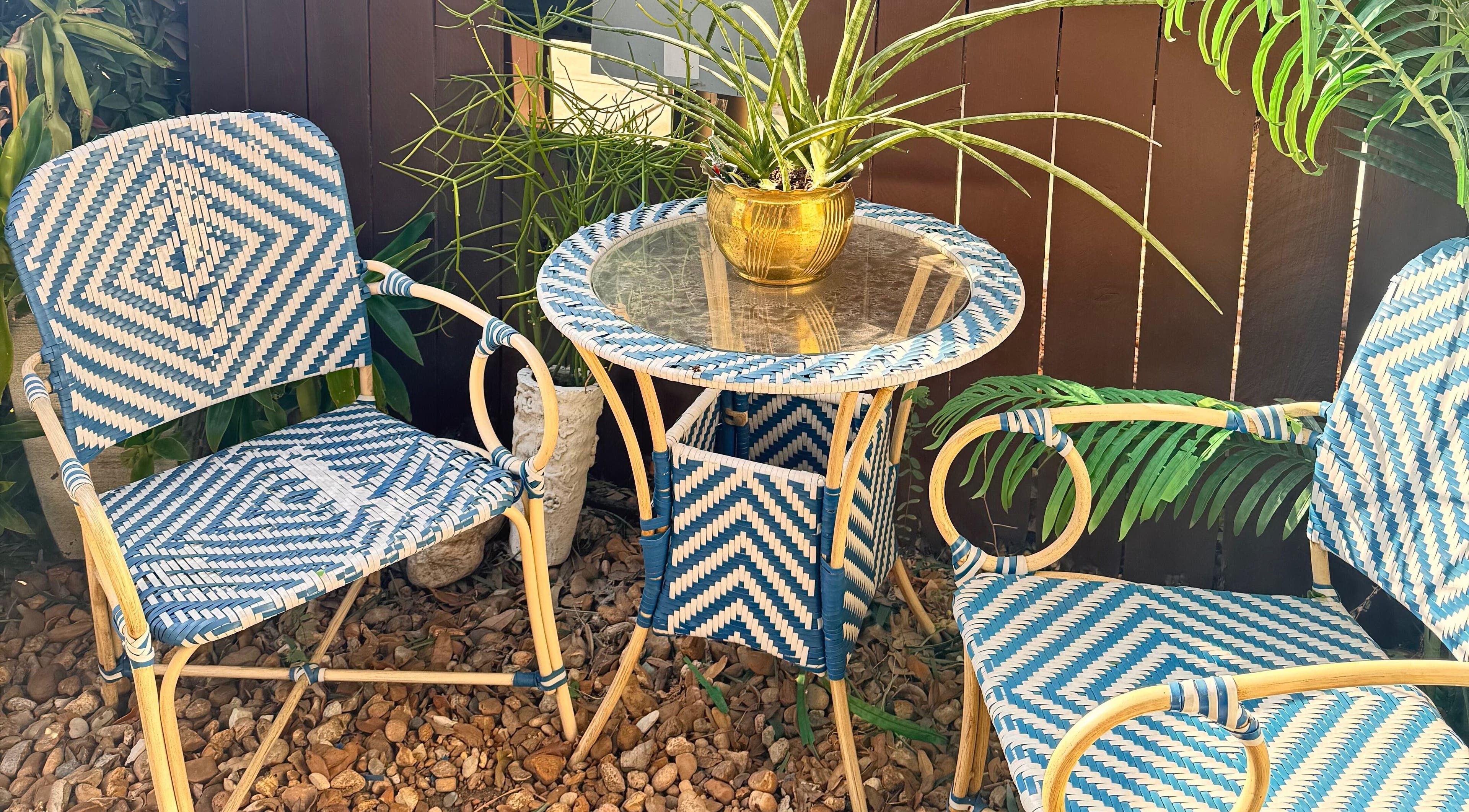 Relaxing outdoor seating area at Jolie Skin Studio, Austin, Texas, US with woven chairs and a glass-top table.