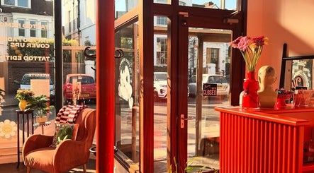 Chic interior of Old Flame Tattoo Removal, Portsmouth, England, bathed in warm natural light.