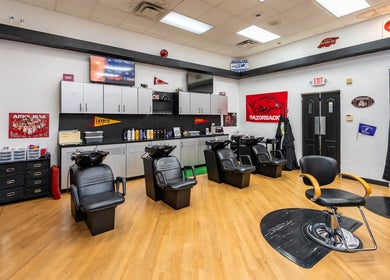 Modern interior of Fantasy Sports Cuts, Fayetteville, Arkansas, US showcasing sleek salon chairs and sports decor.