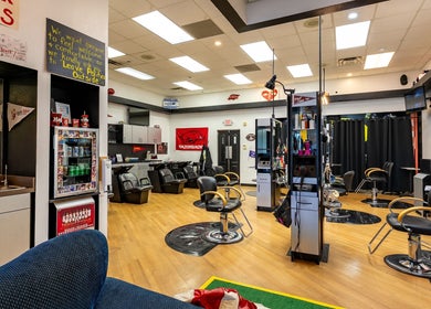 Modern interior of Fantasy Sports Cuts in Fayetteville, Arkansas, US with sleek barber chairs and sports decor.