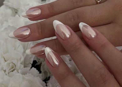 Uñas elegantes con manicura francesa en Ilove Salon, Chihuahua, Chihuahua, MX, rodeadas de flores blancas.