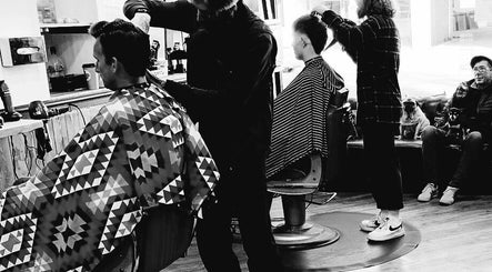 Stylish haircut in progress at Kings Barbers, Horsham, England, GB. Cozy interior with a lively atmosphere.