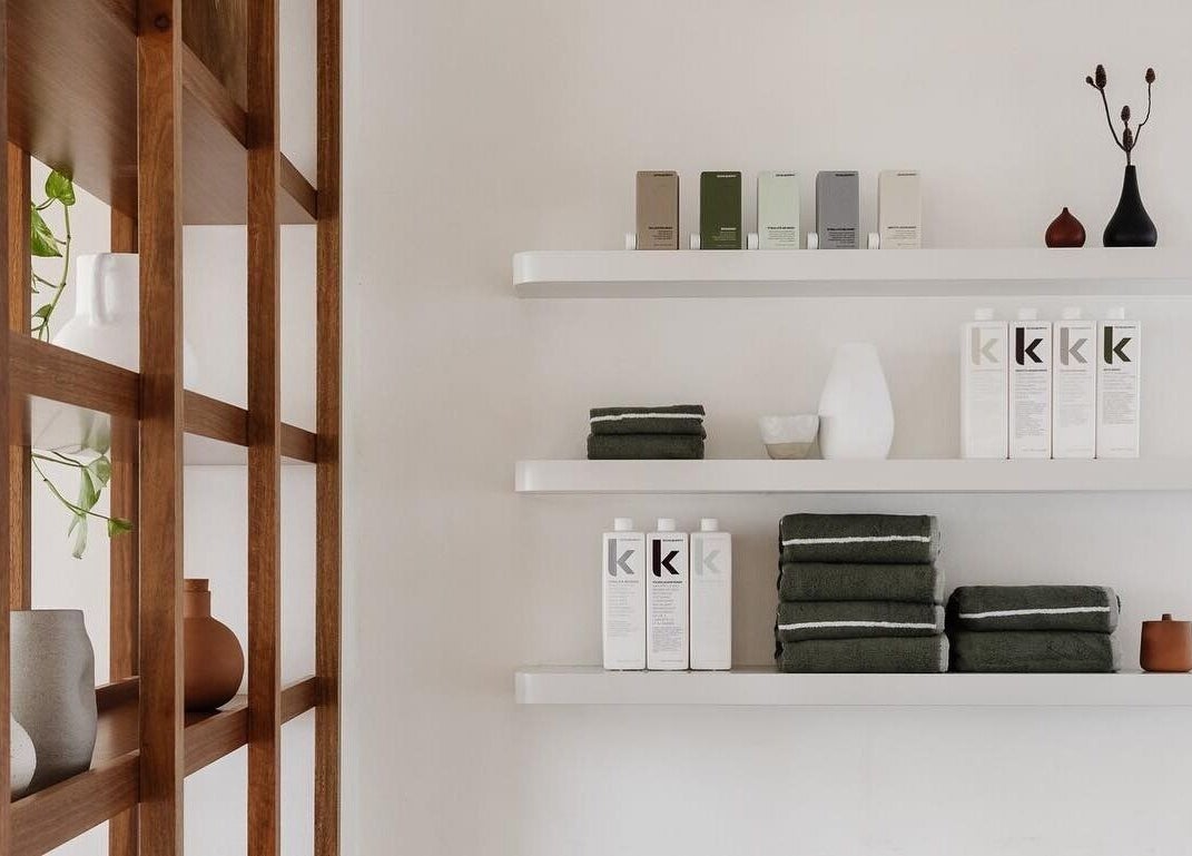 Modern shelving with products at Salon Kaia, Wollongong, NSW, AU, creating a serene and organized space.