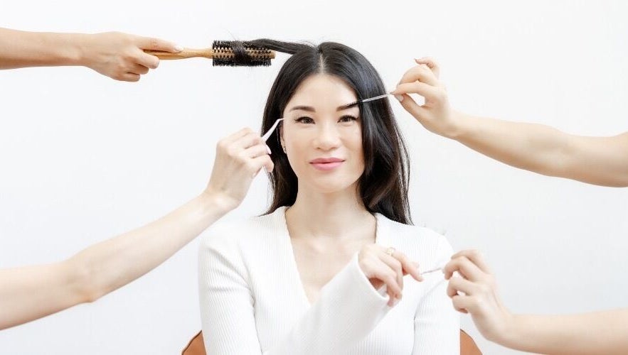 Woman enjoying beauty treatments at Viva in Singapore, SG, featuring hairstyling and brow grooming.