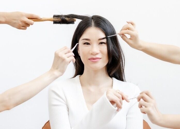 Woman enjoying beauty treatments at Viva in Singapore, SG, featuring hairstyling and brow grooming.