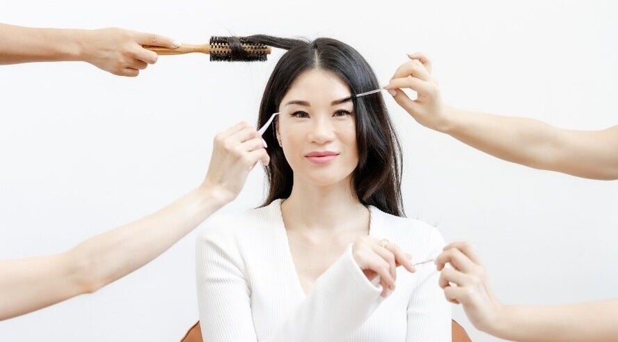 Woman enjoying beauty treatments at Viva in Singapore, SG, featuring hairstyling and brow grooming.