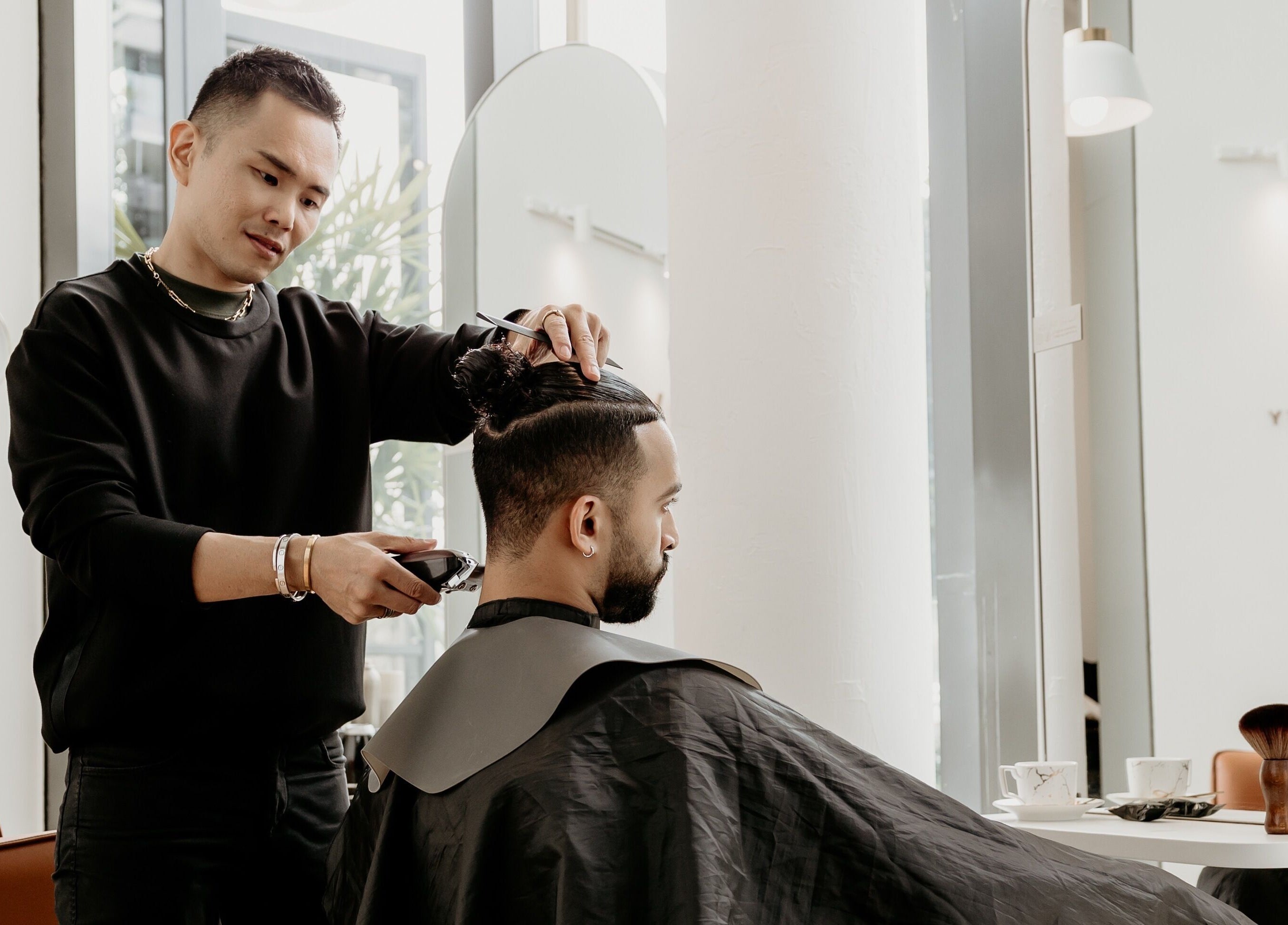 Hairstylist at Viva in Singapore, SG, expertly trims a man's hair in a modern salon setting.