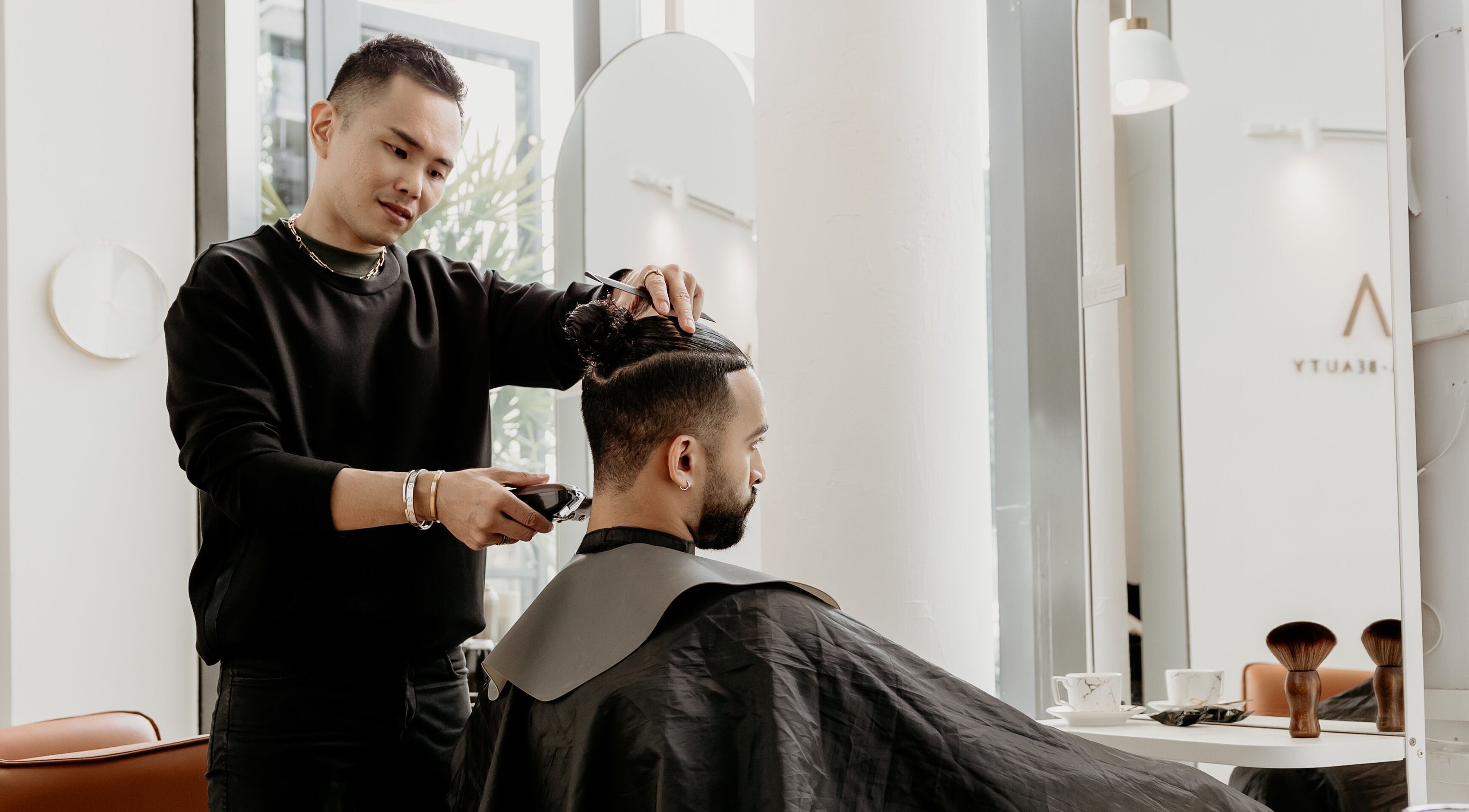 Hairstylist at Viva in Singapore, SG, expertly trims a man's hair in a modern salon setting.