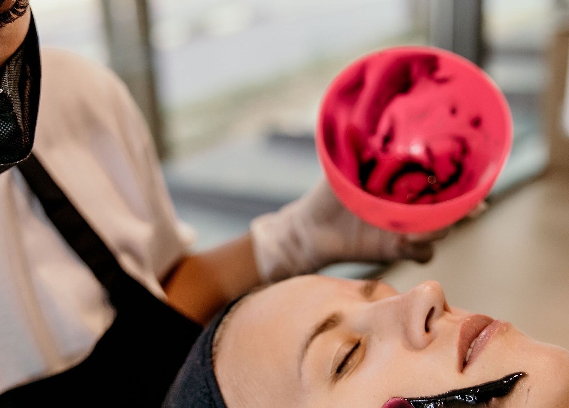 Calming facial treatment at Viva, Singapore, SG, with soothing black mask application for rejuvenation.
