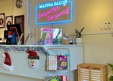 Inviting reception of Mayssa Salon, Cyberjaya. Features decor, neon sign, and products in a cozy setting.
