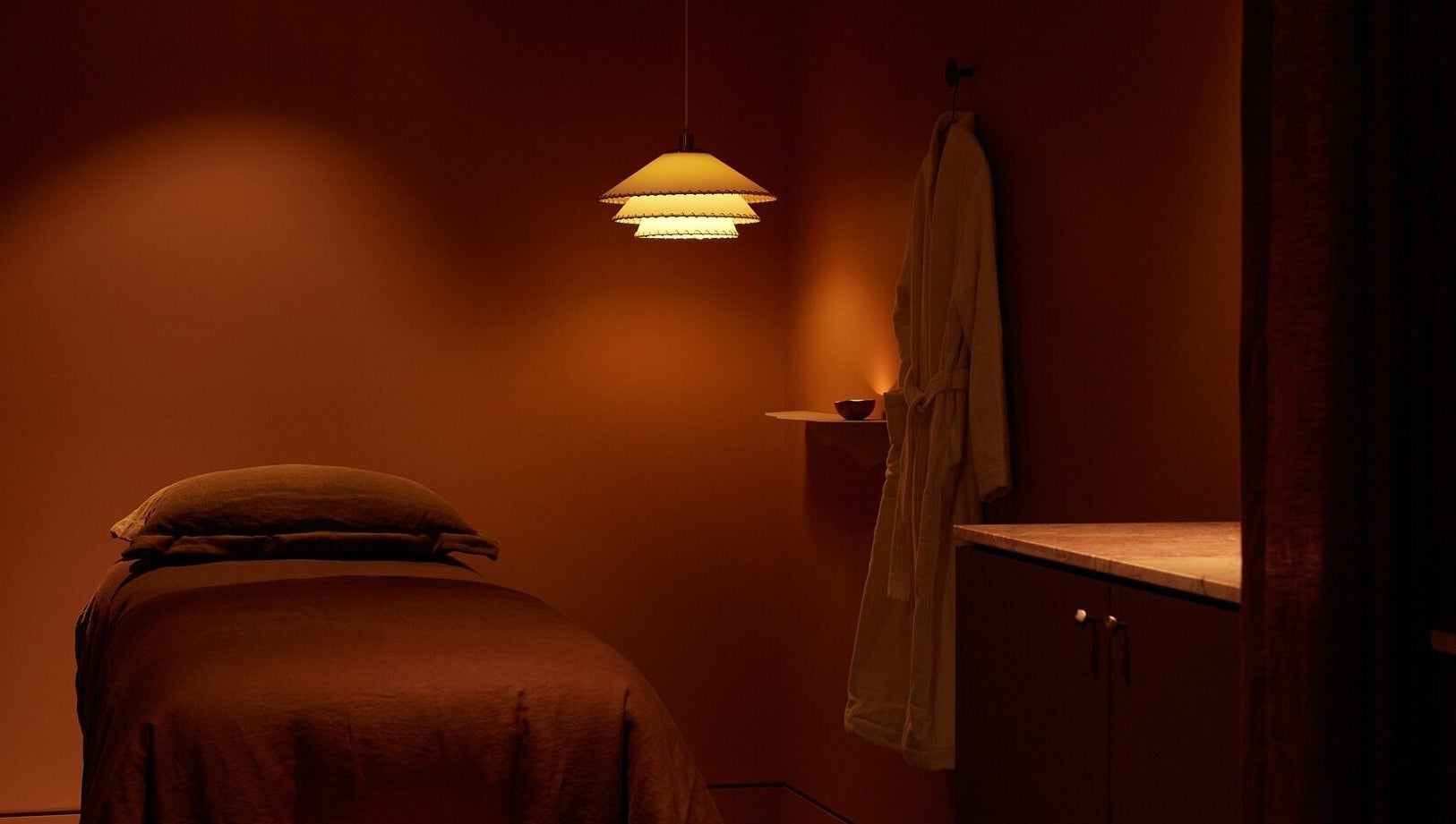 Tranquil treatment room at Comma Byron Bay, Byron Bay, New South Wales, AU, featuring soft lighting and a massage bed.