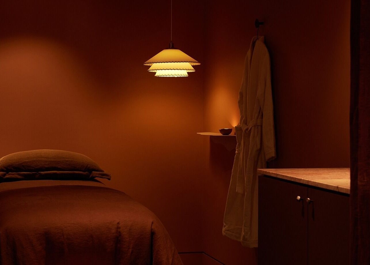 Tranquil treatment room at Comma Byron Bay, Byron Bay, New South Wales, AU, featuring soft lighting and a massage bed.