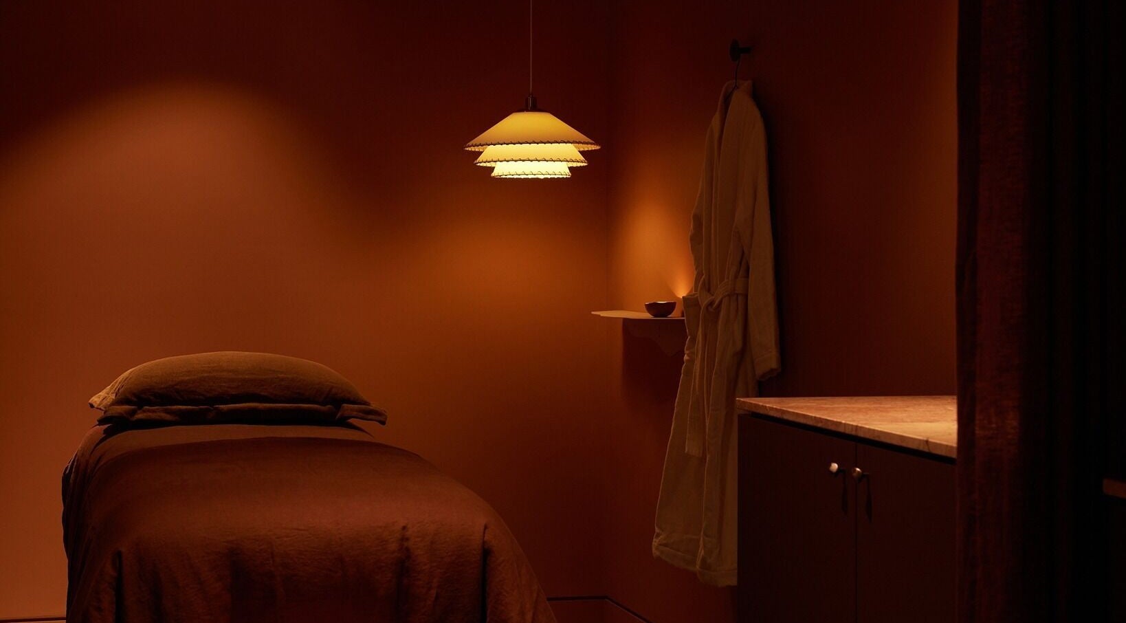Tranquil treatment room at Comma Byron Bay, Byron Bay, New South Wales, AU, featuring soft lighting and a massage bed.