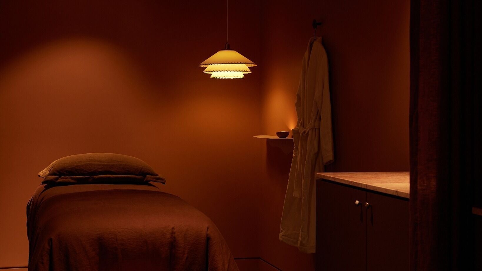 Tranquil treatment room at Comma Byron Bay, Byron Bay, New South Wales, AU, featuring soft lighting and a massage bed.