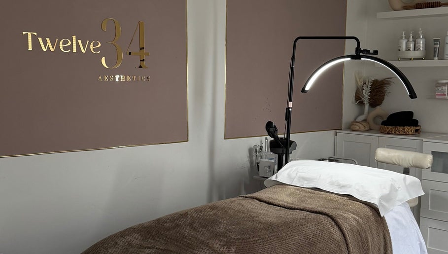 Treatment room at Twelve34 Aesthetics, Luton, England, GB, featuring a cozy bed and modern lighting.