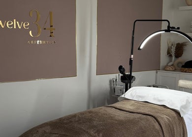 Treatment room at Twelve34 Aesthetics, Luton, England, GB, featuring a cozy bed and modern lighting.