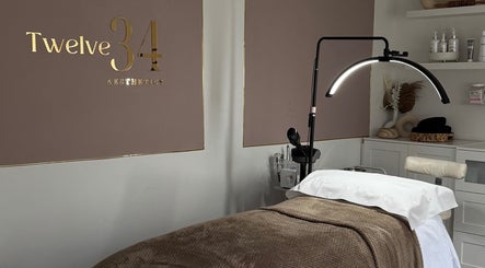 Treatment room at Twelve34 Aesthetics, Luton, England, GB, featuring a cozy bed and modern lighting.