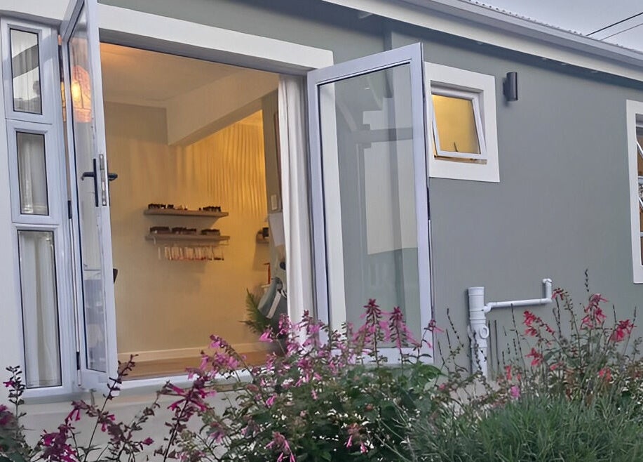 Modern exterior view of Beauty by Kristy in Gqeberha, Eastern Cape, ZA with vibrant flowers.