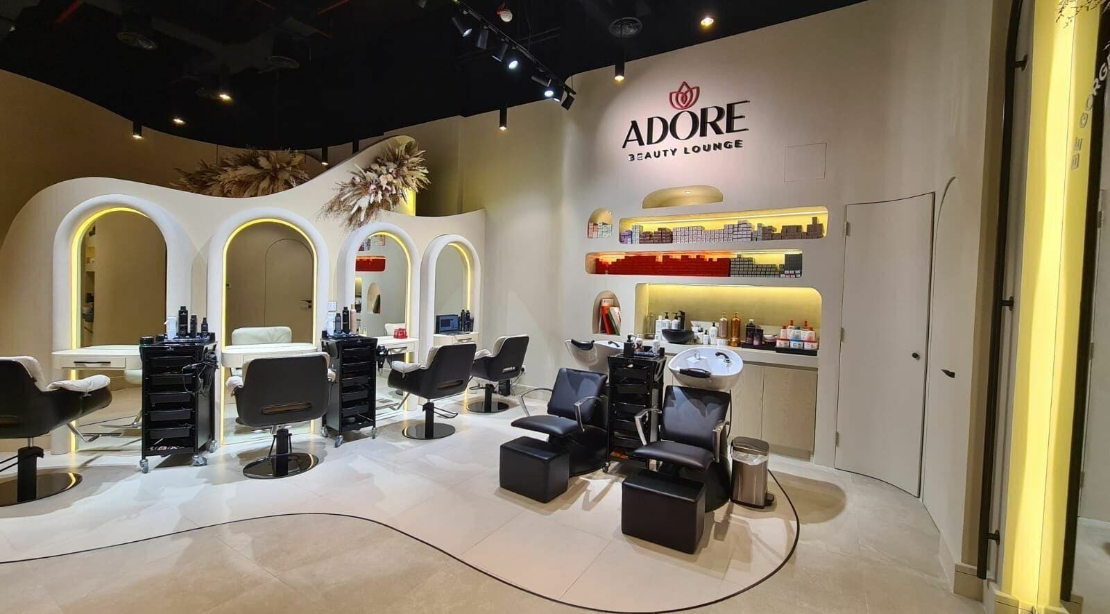 Interior of Adore Beauty Lounge in Dubai, Dubai, AE featuring styling chairs and modern decor.