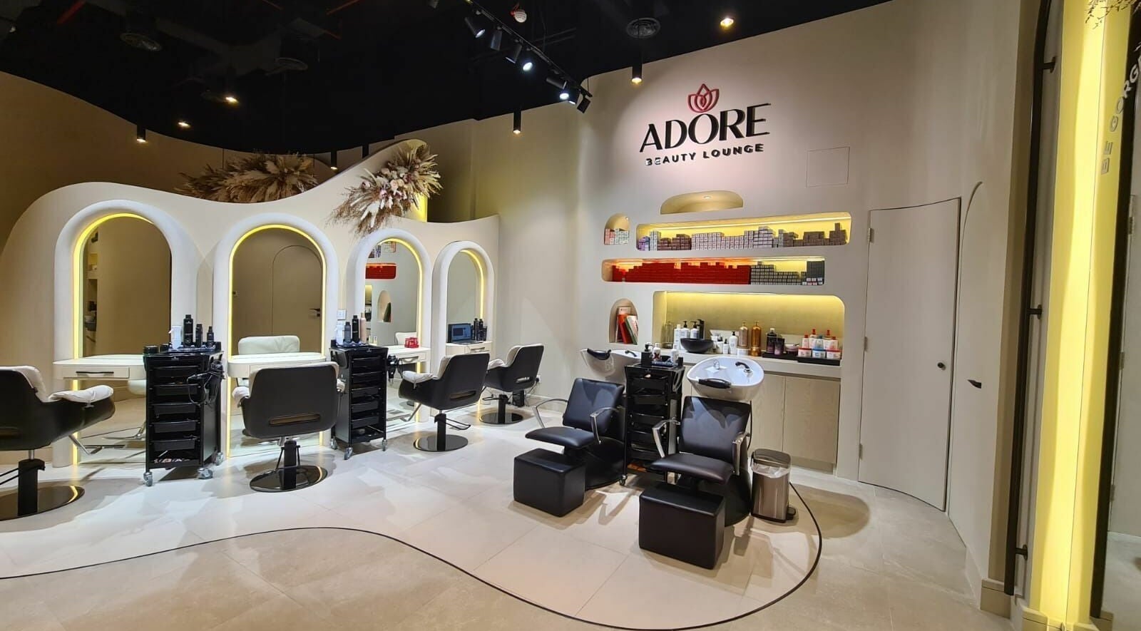 Interior of Adore Beauty Lounge in Dubai, Dubai, AE featuring styling chairs and modern decor.
