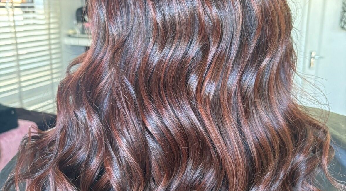 Elegant wavy hairstyle at Artfultistry salon, Cape Town, Western Cape, ZA, showcasing rich, glossy brown curls.