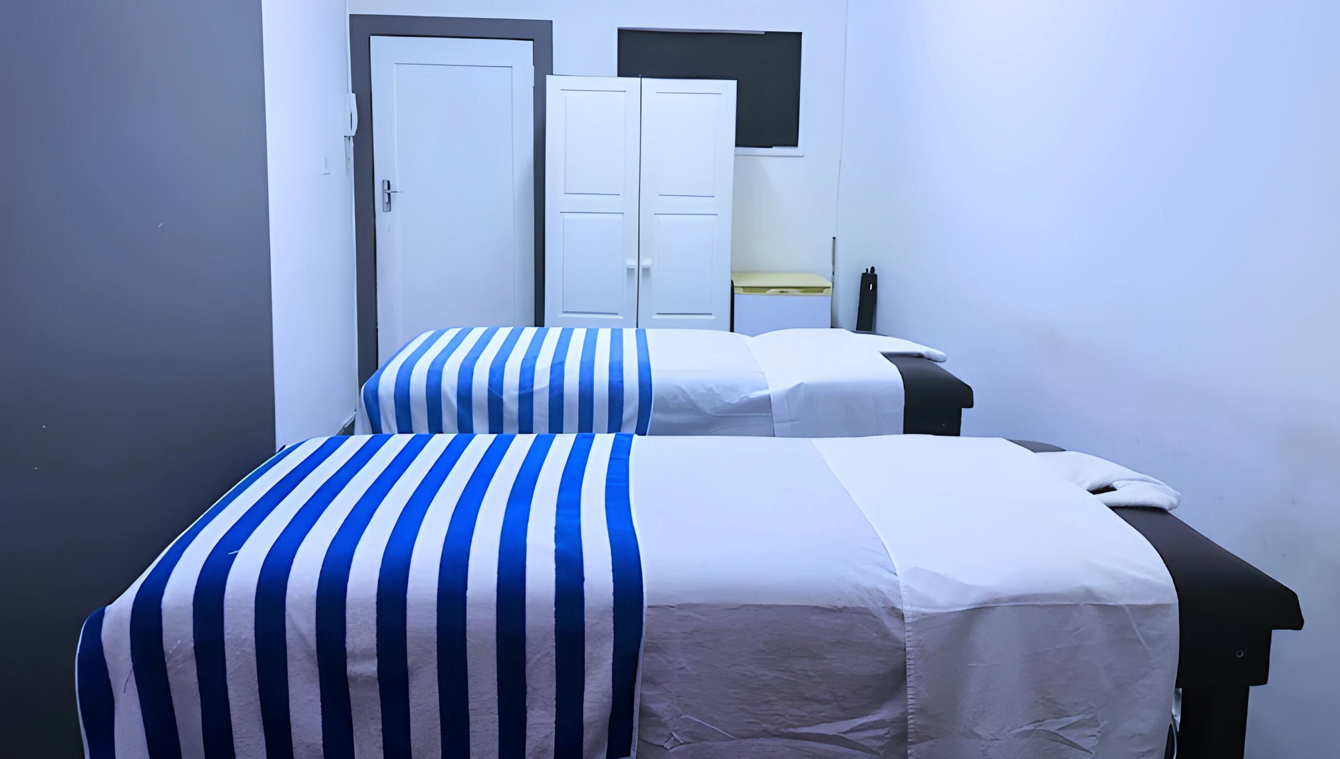 Relaxing massage room at Emmanuel Massage Studio, Cape Town, Western Cape, ZA with two beds and soft lighting.