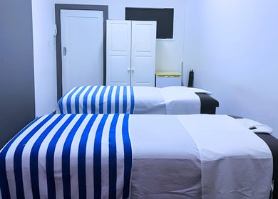 Relaxing massage room at Emmanuel Massage Studio, Cape Town, Western Cape, ZA with two beds and soft lighting.