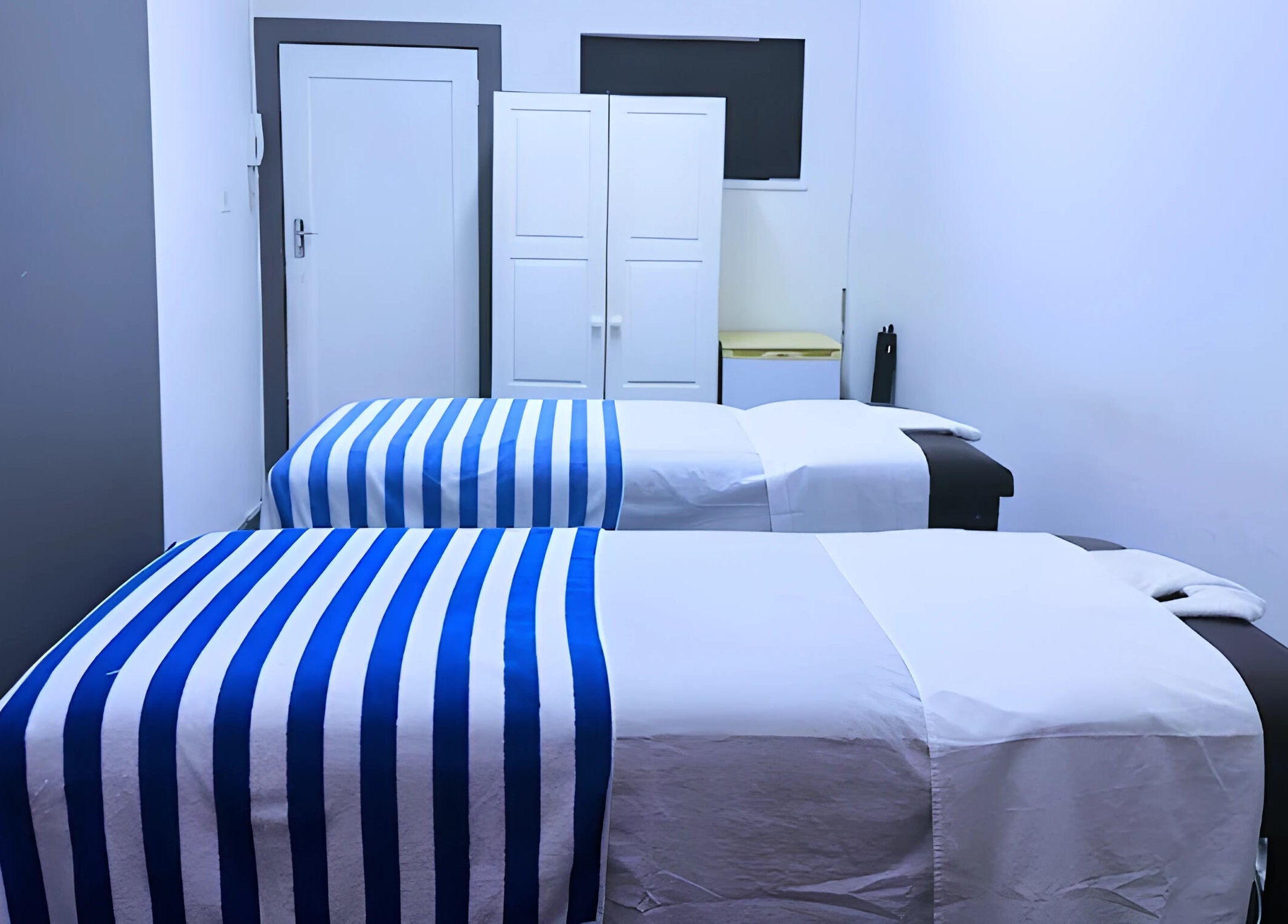 Relaxing massage room at Emmanuel Massage Studio, Cape Town, Western Cape, ZA with two beds and soft lighting.