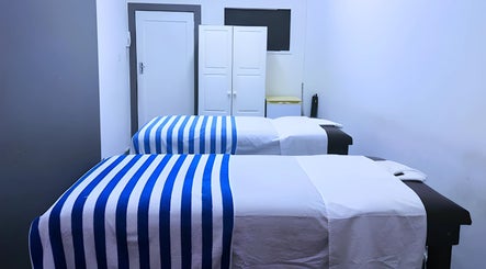 Relaxing massage room at Emmanuel Massage Studio, Cape Town, Western Cape, ZA with two beds and soft lighting.