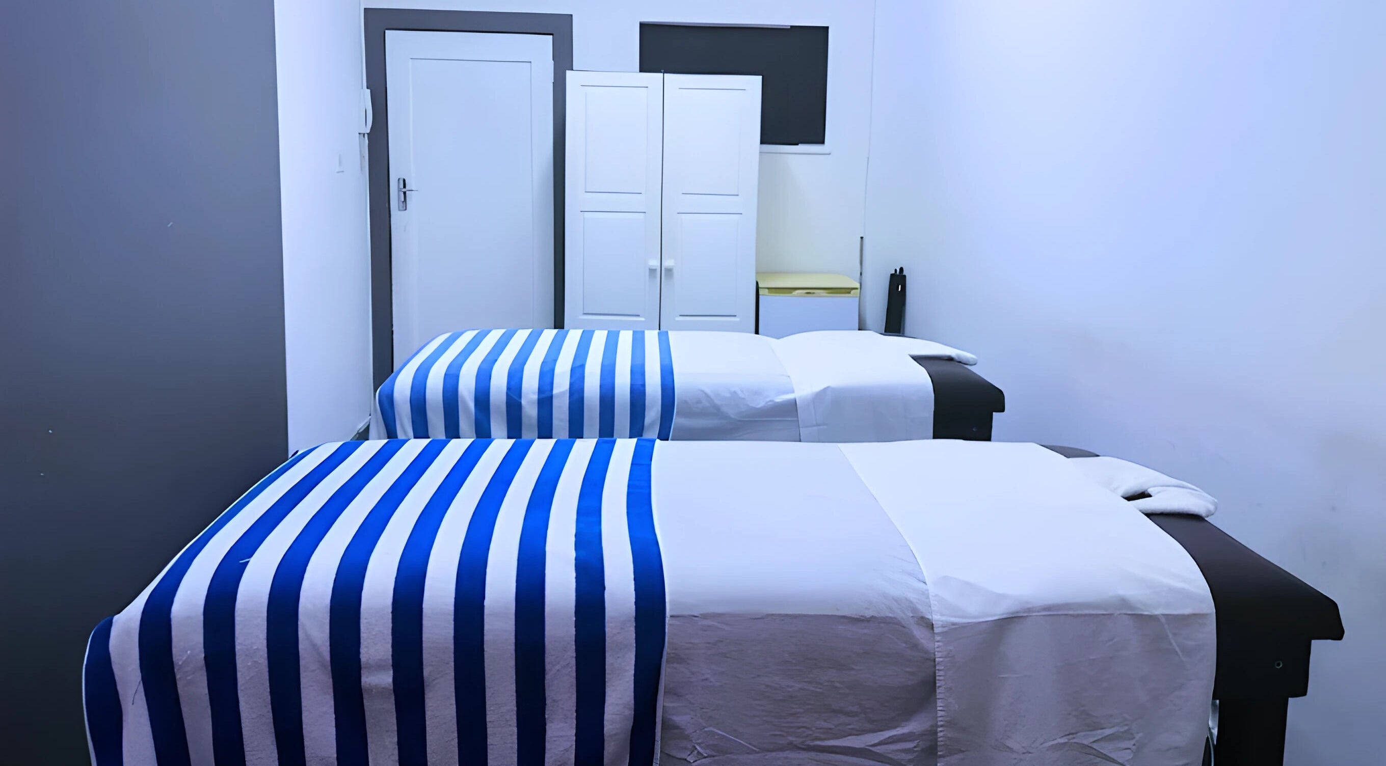 Relaxing massage room at Emmanuel Massage Studio, Cape Town, Western Cape, ZA with two beds and soft lighting.