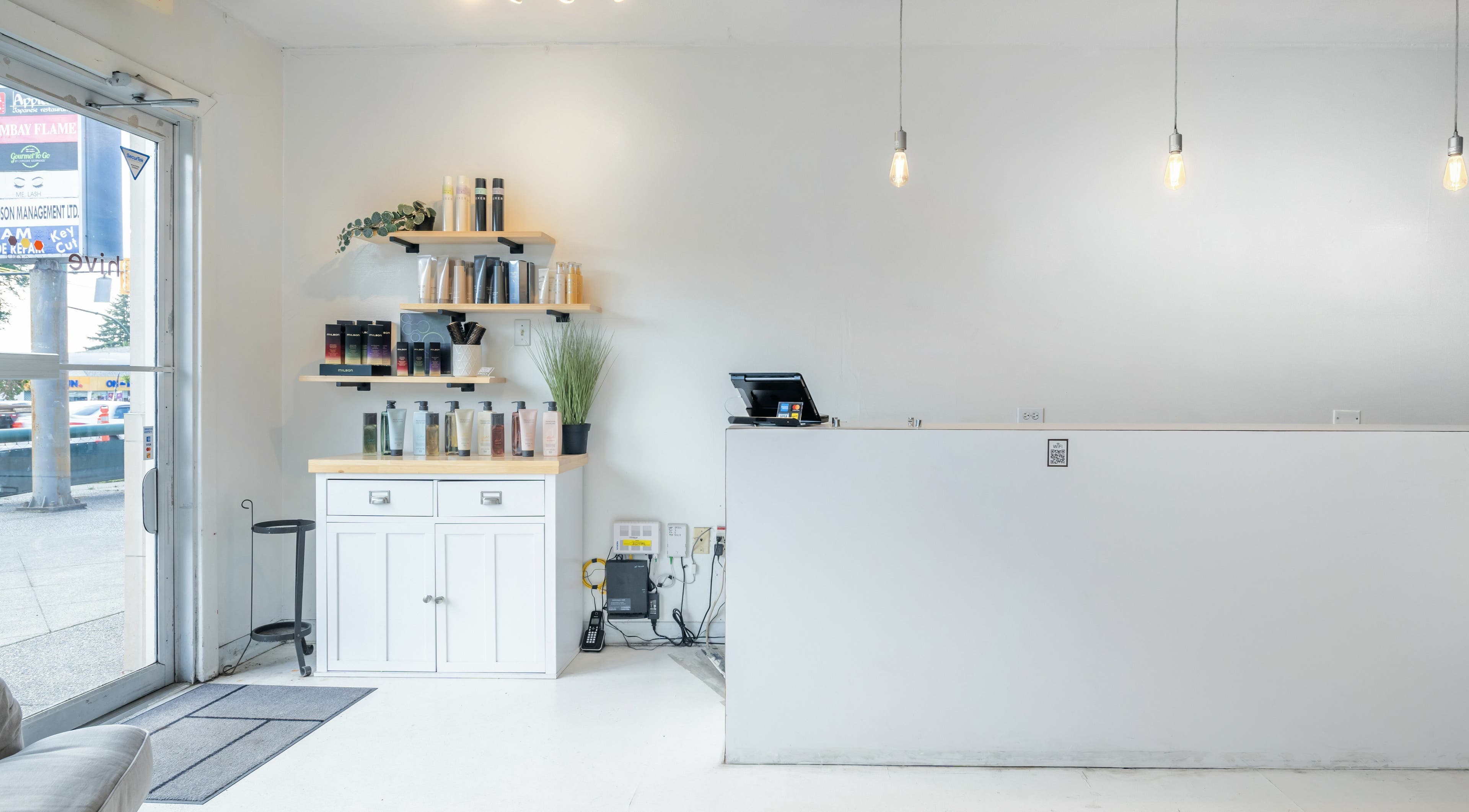 Reception area of Hive Hair Spa at Oak, Vancouver, British Columbia, CA with product shelves and modern decor.