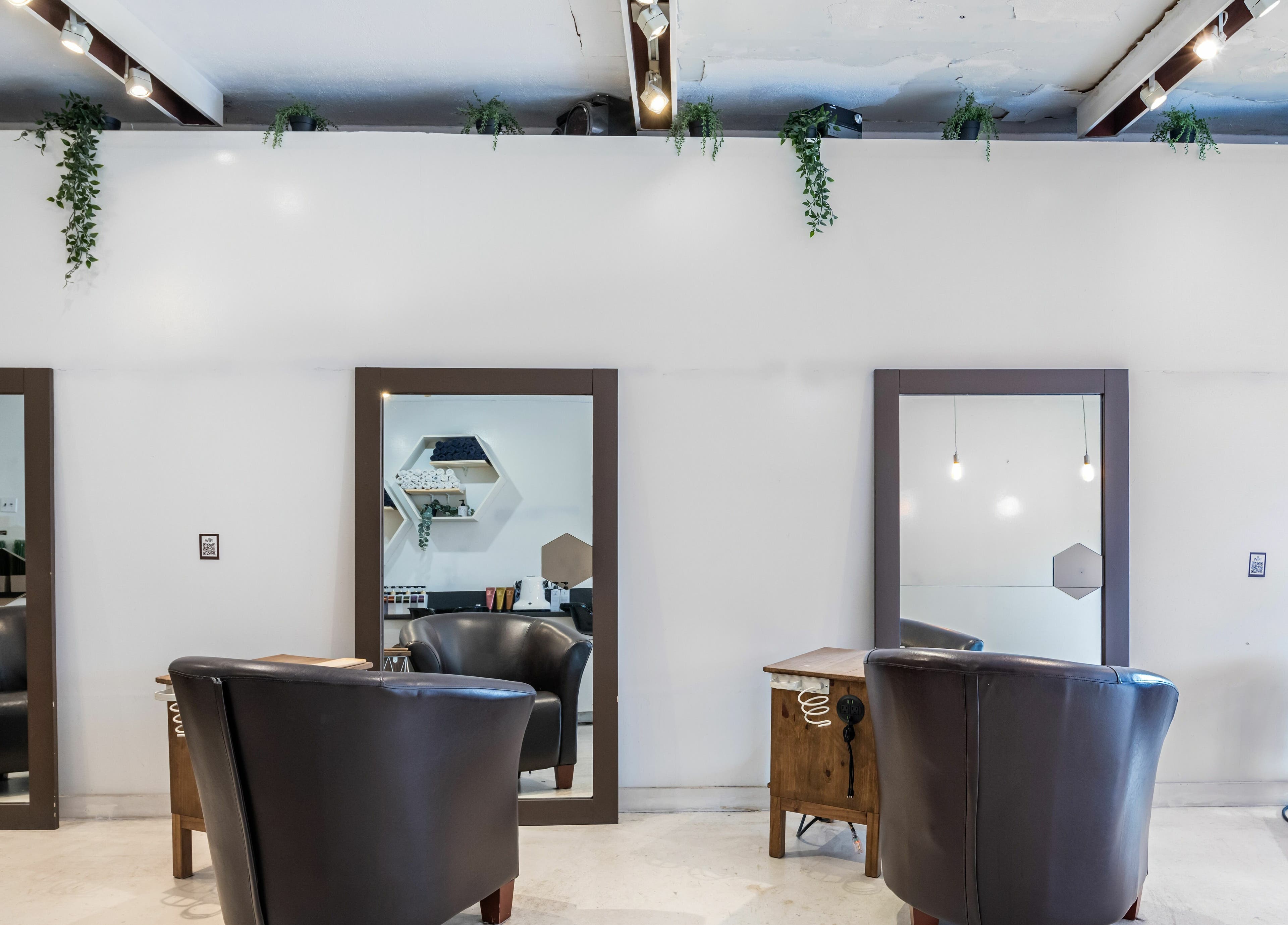 Chic interior of Hive Hair Spa at Oak, Vancouver, British Columbia, CA with plush seating and mirrors.