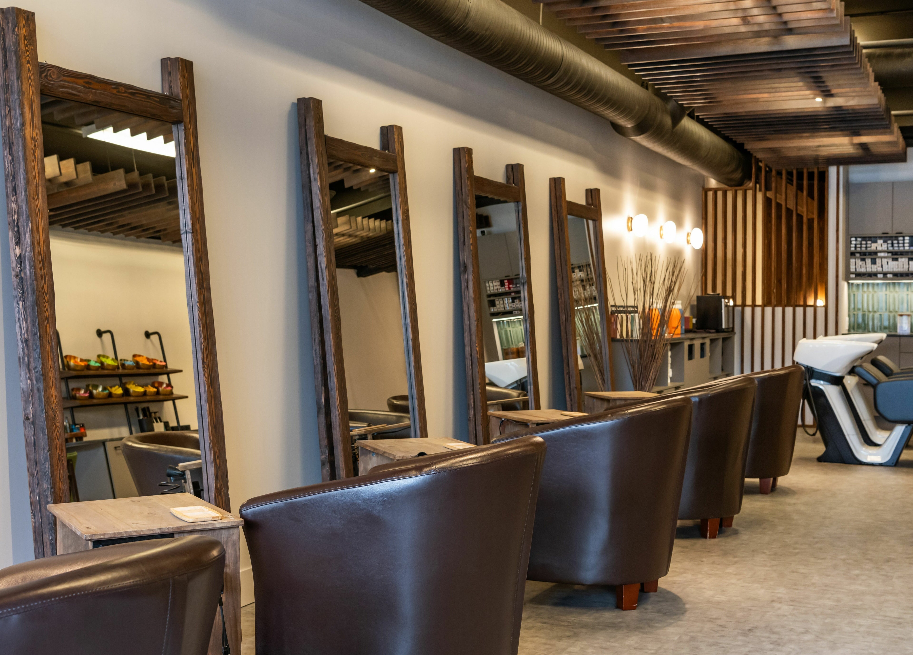 Chic interior at Hive Hair Spa | Broadway, Vancouver, BC, CA, featuring stylish chairs and mirrors.