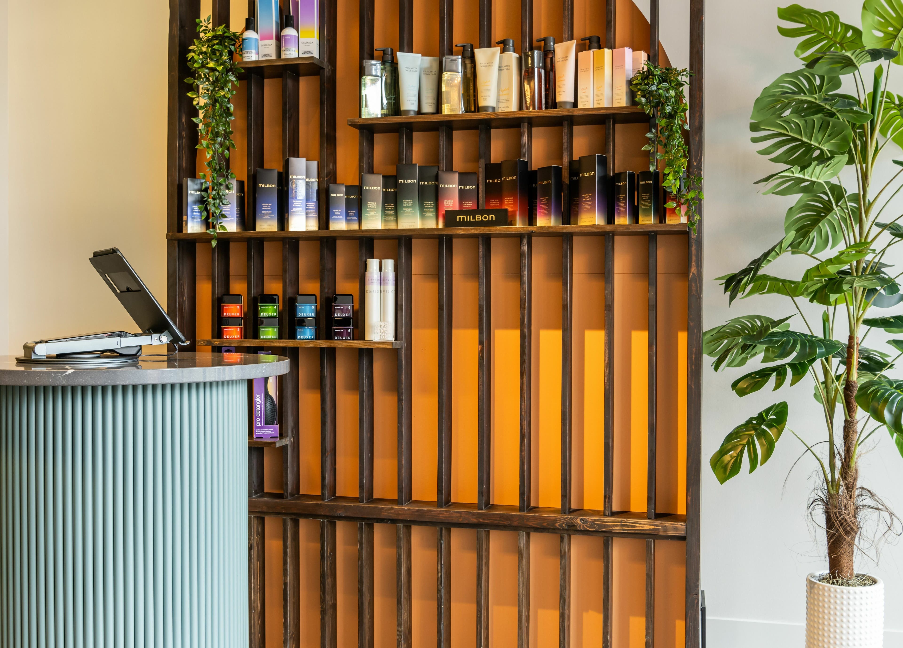 Reception area at Hive Hair Spa | Broadway in Vancouver, British Columbia, CA with green decor and beauty products.