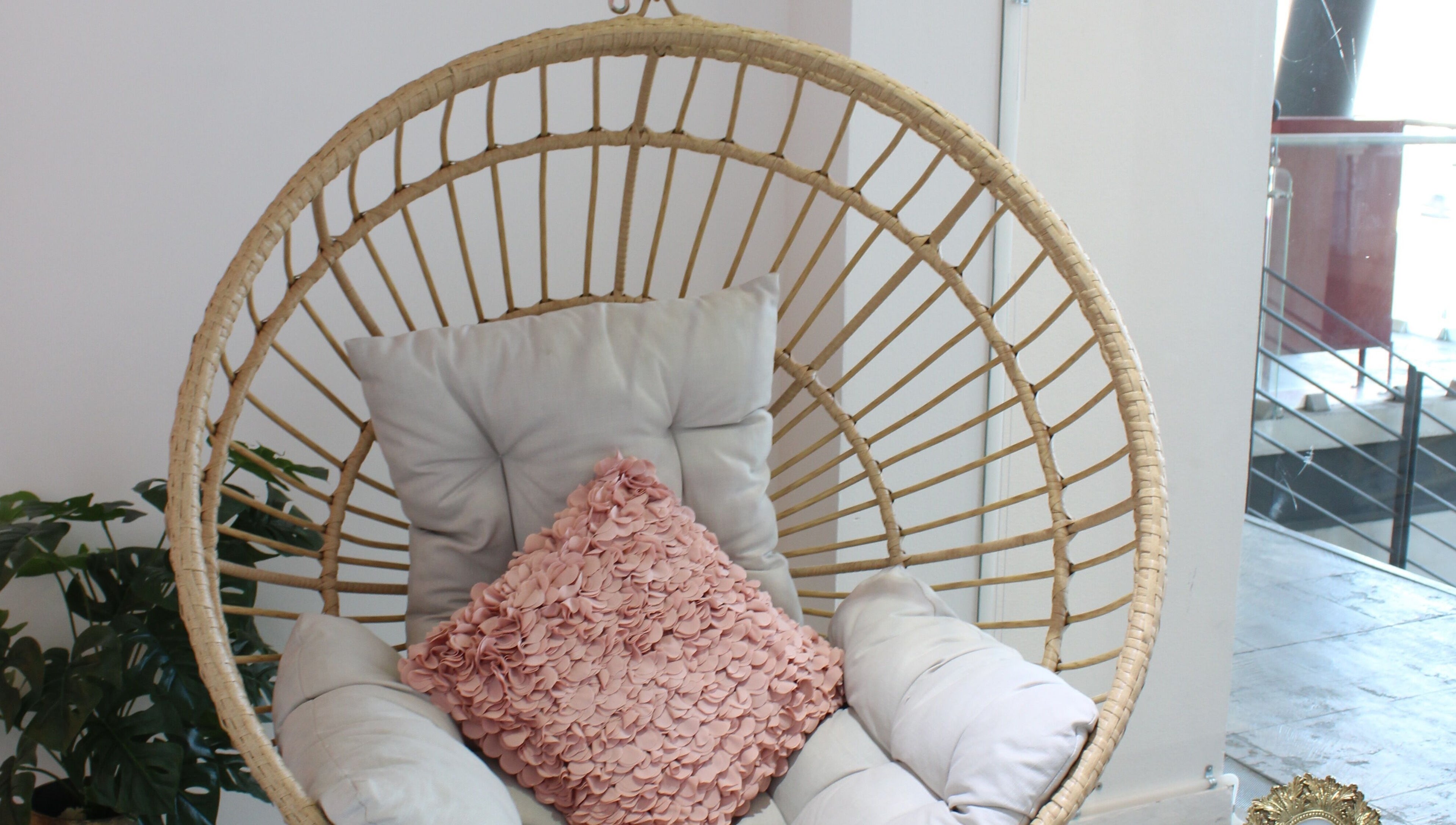 Acogedora silla colgante en Lash Room Refugio, Santiago De Querétaro, Querétaro, MX, con cojín rosa decorativo.