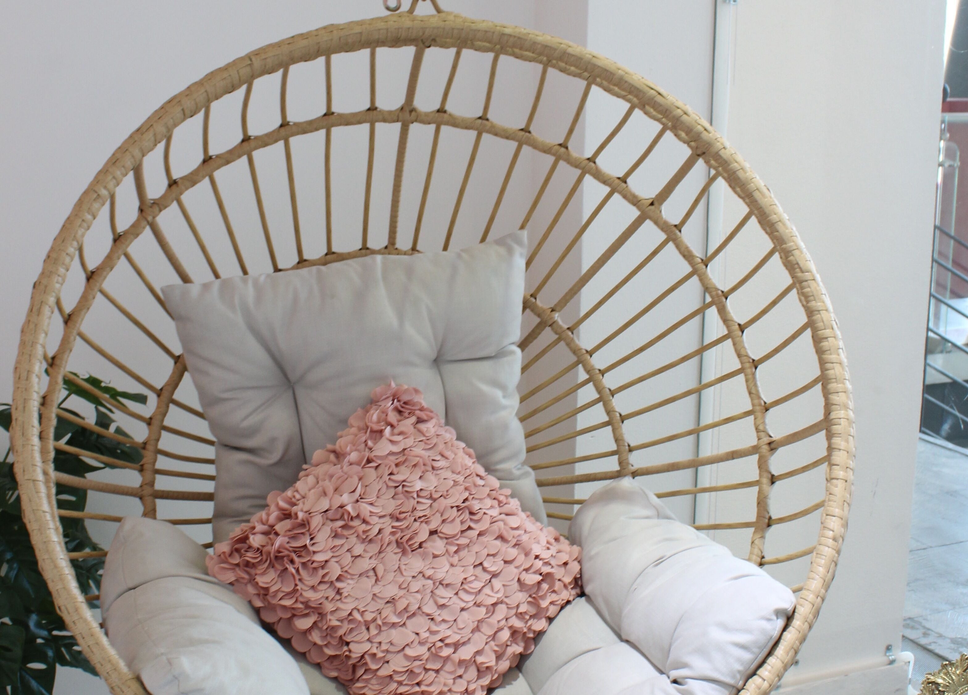 Acogedora silla colgante en Lash Room Refugio, Santiago De Querétaro, Querétaro, MX, con cojín rosa decorativo.