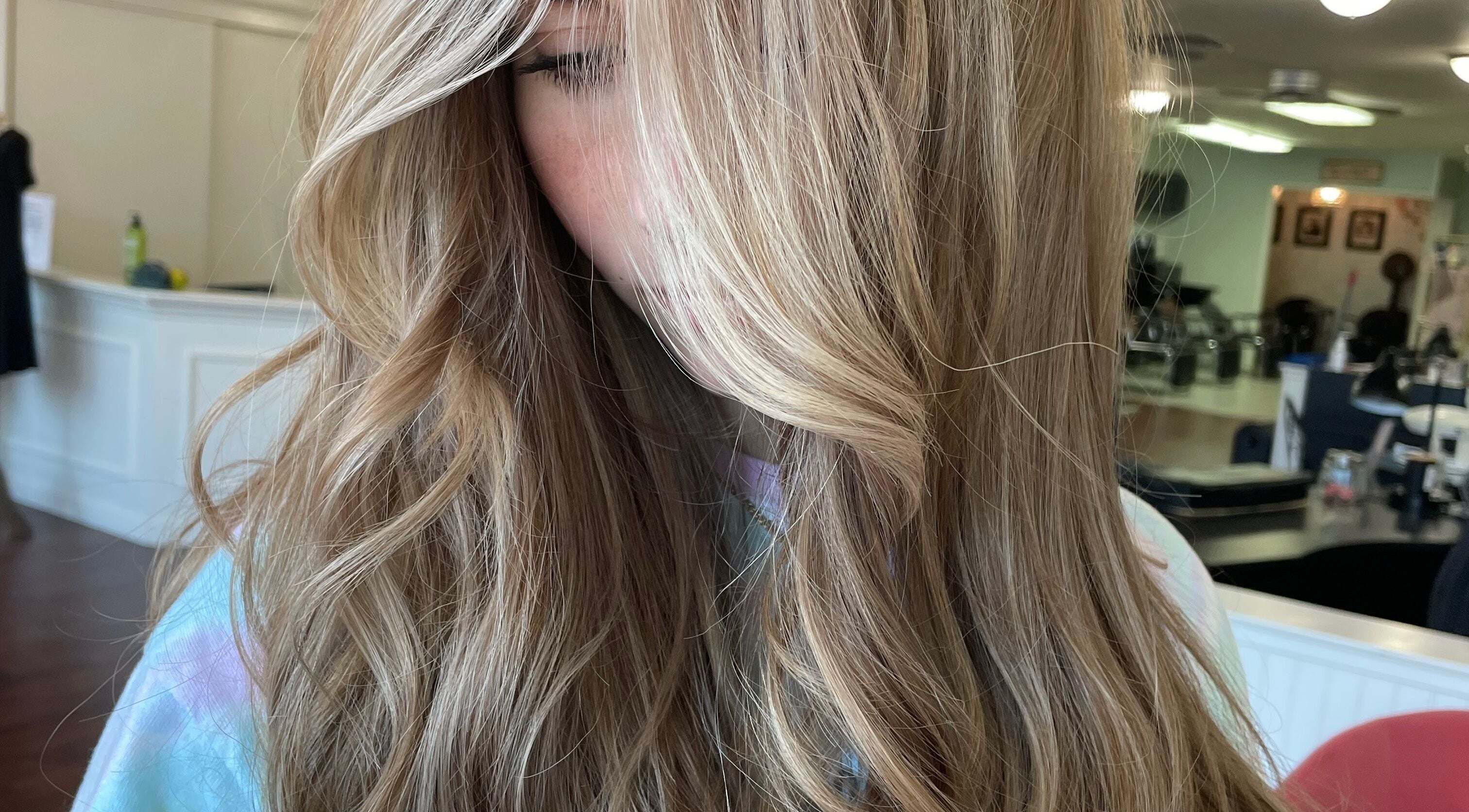 Flowing blonde hair styled at Beauty by Kelly at Studio 13, Vacaville, California, US.