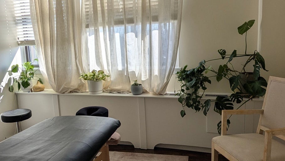 Tranquil massage room at Ugnayan Pratique Holistique (Westmount), Westmount, Québec, CA with natural light and plants.