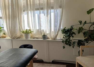 Tranquil massage room at Ugnayan Pratique Holistique (Westmount), Westmount, Québec, CA with natural light and plants.