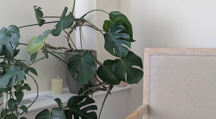 Lush indoor plant beside a cozy chair at Ugnayan Pratique Holistique (Westmount), Westmount, Québec, CA.